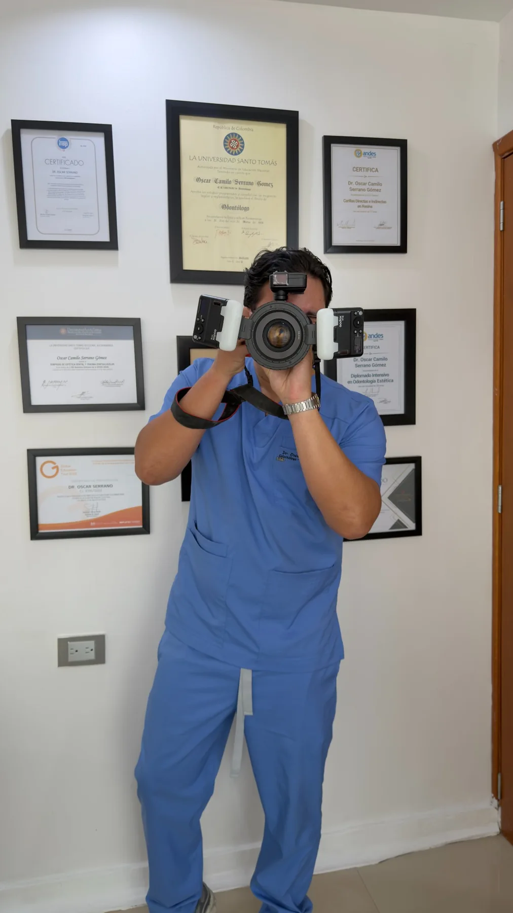 Dr. Óscar Serrano realizando documentación con cámara fotográfica clínica en el consultorio